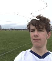 a boy in a white shirt with a blue collar is standing in a field