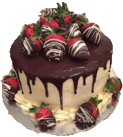 a cake with chocolate covered strawberries on top on a silver plate