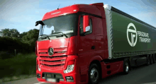 a red mercedes truck is driving down a road with fergoraki transport on the side