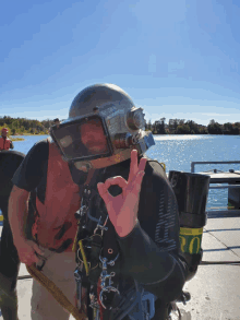 a man wearing a scuba helmet giving the ok sign