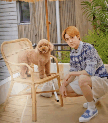 a man kneeling down next to a chair with a small dog on it