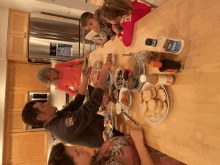 a family sits at a table with plates of food and a bottle of ranch