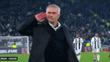 a man salutes on a soccer field in front of a sign that says " all game "