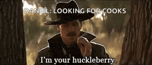 a man in a cowboy hat is talking on a cell phone and says i 'm your huckleberry