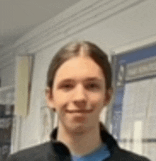 a young man with long hair is smiling for the camera .