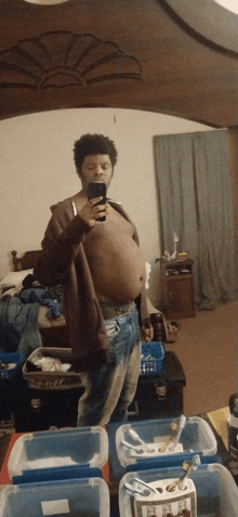 a man taking a picture of himself in front of a mirror with boxes of toothbrushes in front of him