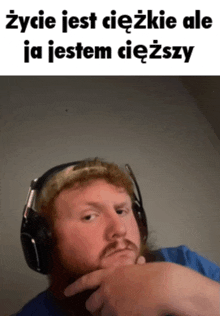 a man wearing headphones has his hand on his chin and says życie jest ciezkie ale ja jestem ciedzy