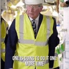 a man in a suit and tie wearing a hard hat and safety vest is standing in a room .