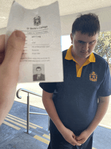 a person holding up a st. george identification card