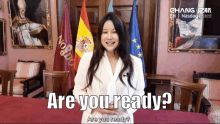 a woman standing in front of flags says are you ready