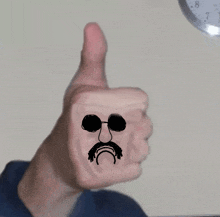 a person giving a thumbs up with a drawing of a man 's face on it