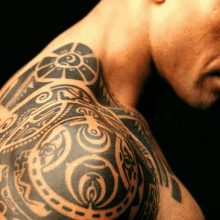 a close up of a man 's shoulder with a tribal tattoo