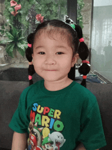 a little girl wearing a green super mario t-shirt