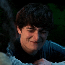 a young man is smiling while hugging another man .