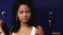 a woman is standing in front of a blue locker .