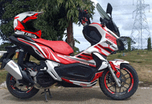 a red and white honda adv 150 motorcycle with a helmet on top of it