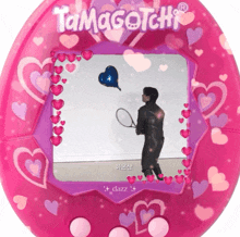 a pink tamagotchi with hearts and a man holding a tennis racket