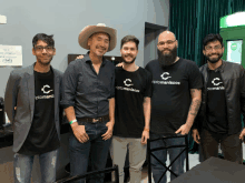 a group of men are posing for a picture and one of them is wearing a shirt that says " cryptomaniacos "