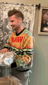 a man wearing a raw sweater is holding a gift