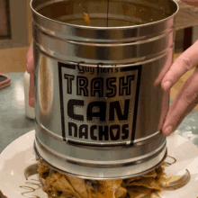 a person is holding a trash can that says " trash can nachos "