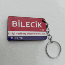 a red white and blue keychain that says bilecik