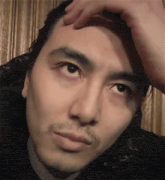 a close up of a man 's face with his hand on his head