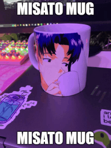 a misato mug is on top of a laptop