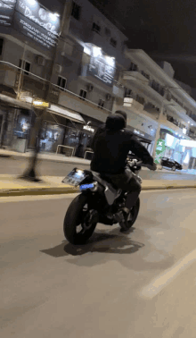 a man is riding a motorcycle down a street with a license plate that says aa - aa - 7