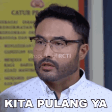 a man with glasses and a beard has the words kita pulang ya on his face