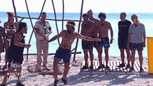 a group of people standing on a beach with a sign that says in diretta date honduras la tana dei serpenti