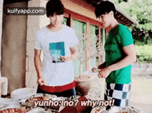 two men are standing next to each other at a table with food . one of the men is asking the other why not .