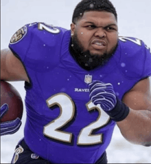 a man in a ravens uniform is running with a ball