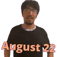 a man wearing glasses is wearing a black shirt that says august 22