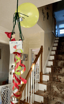 an elf on the shelf is hanging from a balloon with a sign that says ' anna ' on it