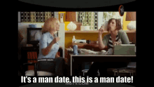 two women sitting at a desk with the words " it 's a man date this is a man date " above them