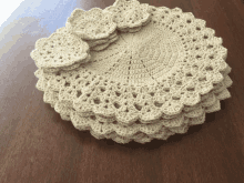 a stack of crocheted placemats and coasters on a table