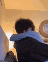 a couple hugging each other in a room with a mirror in the background