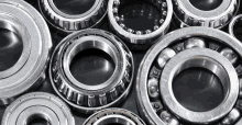 a bunch of metal bearings are lined up on a black surface