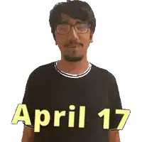 a man wearing glasses and a black shirt that says april 17 on it