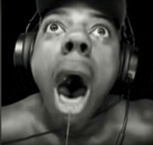 a black and white photo of a man wearing headphones with his mouth open