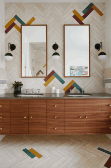 a bathroom with two sinks and two mirrors with colorful tiles on the walls