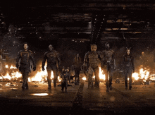 the guardians of the galaxy are standing in front of a fire