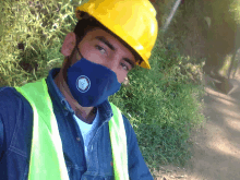 a man wearing a yellow hard hat and a blue mask with a logo that says ' a ' on it