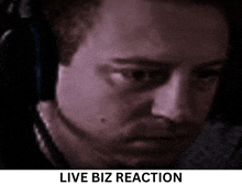 a close up of a man 's face with the words live biz reaction below