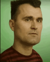 a man in a striped shirt is looking at the camera