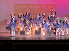 a group of children are on a stage in front of a sign that says run ! run ! run !