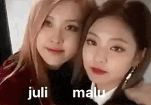 two women are posing for a picture together and one of them is wearing a red jacket .