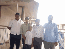 a group of people posing for a picture including a boy wearing a white shirt with circles on it