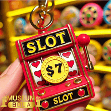 a person is holding a slot machine with hearts and a dollar coin