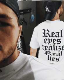 a man wearing a shirt that says " real eyes realize real lies "